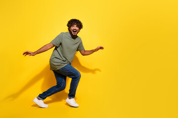 Full size photo of funky guy dressed khaki t-shirt jeans steal on tiptoes near promo empty space...