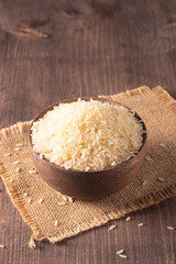 Uncooked white rice in a wooden bowl. Healthy cereal concept.  