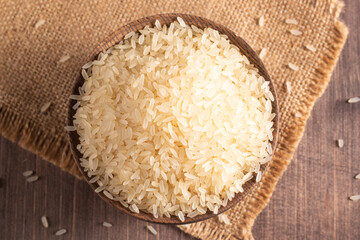 Uncooked white rice in a wooden bowl. Healthy cereal concept.  