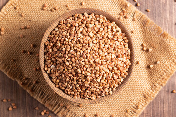 Buckwheat groats on wooden background. Healthy cereal concept