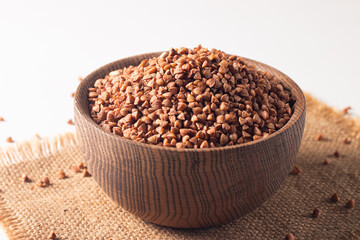 Buckwheat groats on wooden background. Healthy cereal concept