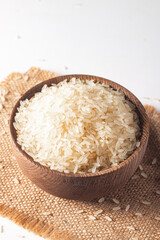 Uncooked white rice in a wooden bowl. Healthy cereal concept.  