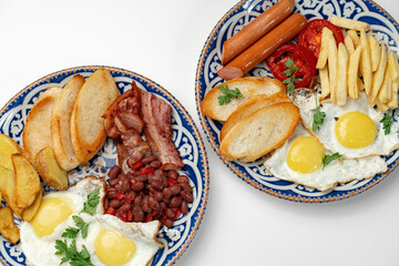 Two plates of a hearty breakfast served on decorative bowls