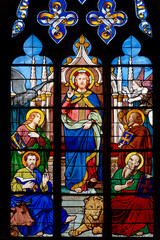 Stained glass (19th century) of The four evangelists at Christ's feet: Luke and the bull, Mark and...