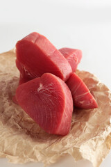 Tuna slices on white plate. Steaks from fresh tuna fillet. An isolated object. White background. Vertical photo.