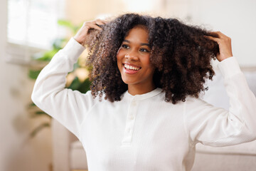 Fototapeta premium Hair care, portrait of african american girl smiling happy with her afro hair it home