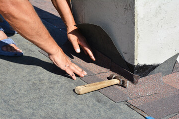 Asphalt shingles roofing construction. Roofer repair and laying asphalt shingles with vapor barrier...