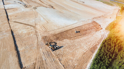 Construction vehicles working on large dirt site