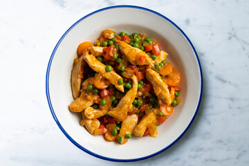 Sautéed chicken strips with vegetables and tomato sauce. Top view table with  decoration.