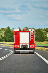 Red fire truck driving down residential street in town
