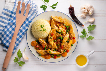 Sautéed chicken strips with vegetables and tomato sauce. Top view table with  decoration.
