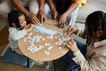 Cozy living room with family engaging in puzzle activity, children and adults bonding and sharing...