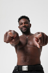 African American athletic young man shirtless pointing at the camera. Mock-up.