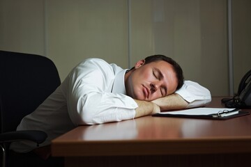 Fototapeta premium Businessman sleeping on his desk in the office,