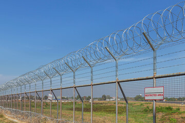 Razor barbed wire or concertina razor coil barrier security fence restricted area protection with...