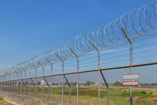 Razor barbed wire or concertina razor coil barrier security fence restricted area protection with blue sky   