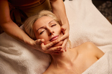 Serene Spa Experience with Relaxing Facial Massage. A woman enjoys a calming spa treatment with a...