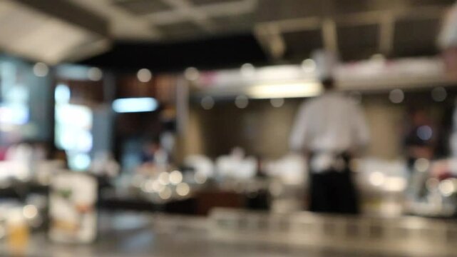 Chef cooking in restaurant kitchen blurred defocused background