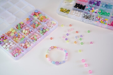 Making handmade beaded jewelry in workplace. Fashion, creativity, bracelets with beads and stones. Handmade jewelry, small business, hobby concept.