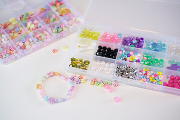 Making handmade beaded jewelry in workplace. Fashion, creativity, bracelets with beads and stones. Handmade jewelry, small business, hobby concept.