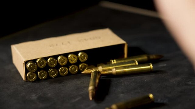 A man drops another round of ammunition near a pile.