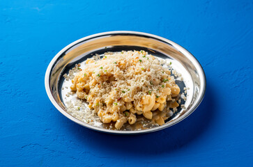 Truffle Mac and Cheese creamy macaroni served in steel plate isolated on blue background side view of italian pasta food