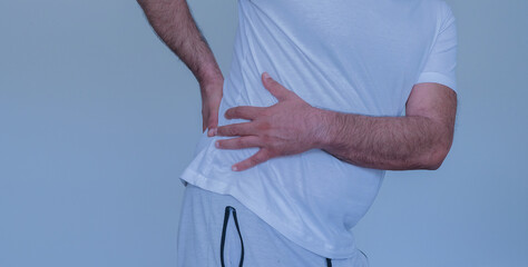 Man suffering from back pain holds his waist