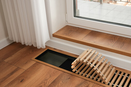 Contemporary water underfloor heat convector installed near panoramic window. Energy consumption in cold season. Concept of smart home. Side view.