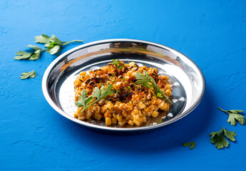 Mexican Style Grilled Corn kernel with with Chili, Lime and coriander served in plate isolated on blue background side view of spicy grill vegan snack