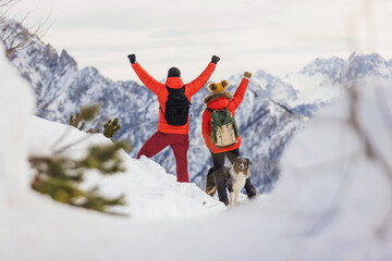 Hikers celebrate the achievement of reaching the top of the mountain in winter