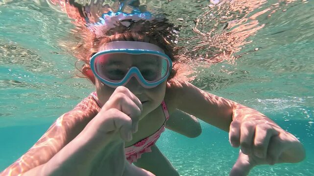 Girl snorkeling underwater in clear blue Mediterranean sea near Kardamena town, Kos, Greece
