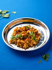 Mexican Style Grilled Corn kernel with with Chili, Lime and coriander served in plate isolated on blue background closeup side view of spicy vegan snack