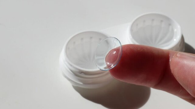 Removing a contact lens from the case. Close-up of a contact lens on a woman&rsquo;s finger for vision correction. the concept of correcting myopia and hyperopia.