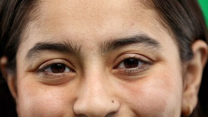 Obraz premium Woman's eyes, close-up, on a green background