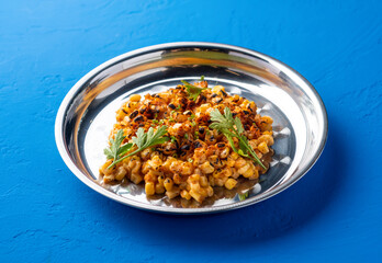 Mexican Style Grilled Corn kernel with with Chili, Lime and coriander served in plate isolated on blue background side view of spicy vegan snack