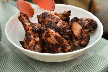 Grilled chicken wings, ready to eat, lie on a plate.