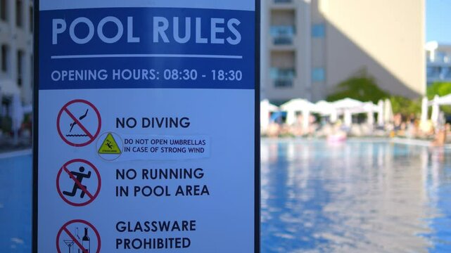 Pool rules sign with swimming pool in resort background in 4k slow motion 60fps