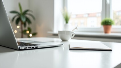 Fototapeta premium Modern workspace with a laptop, notepad, and coffee cup in a cozy home setting