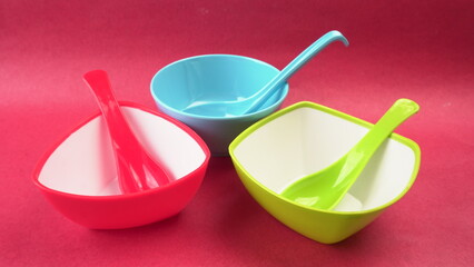 Stack of colorful empty plastic bowls over colourful background.