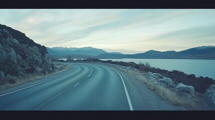 Winding road through the Scottish Highlands, with misty hills and sheep grazing alongside the route