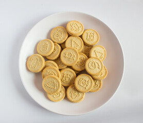 round cookies with various designs on them, including Christmas themed symbols like trees, snowmen, and other festive characters. vanilla or butter flavored sandwich cookies.