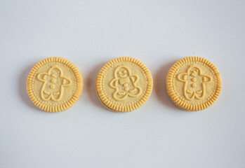 round cookies with various designs on them, including Christmas themed symbols like trees, snowmen, and other festive characters. vanilla or butter flavored sandwich cookies.