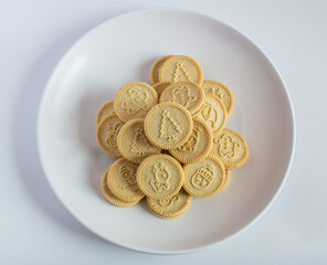 round cookies with various designs on them, including Christmas themed symbols like trees, snowmen, and other festive characters. vanilla or butter flavored sandwich cookies.