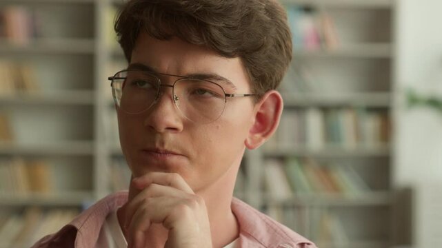 Portrait pensive thinking thoughtful Caucasian teen boy student guy male pupil man teenager in glasses looking searching solution think hesitate decision studying learning in school university library