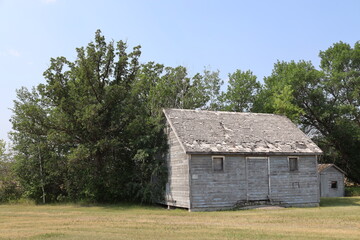 Obraz premium wide-angle rural farmhouse and shed falling into disrepair