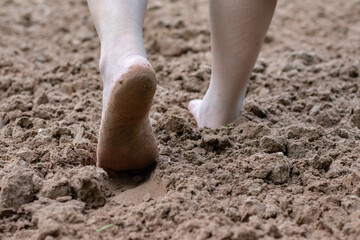 Closeup barefoot walking on sand floor of patient after recovering from hospital to treat body balance and alternative medical treatment of people after surgery, soft focus.