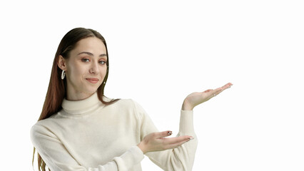 A woman, close-up, on a white background, points to the side