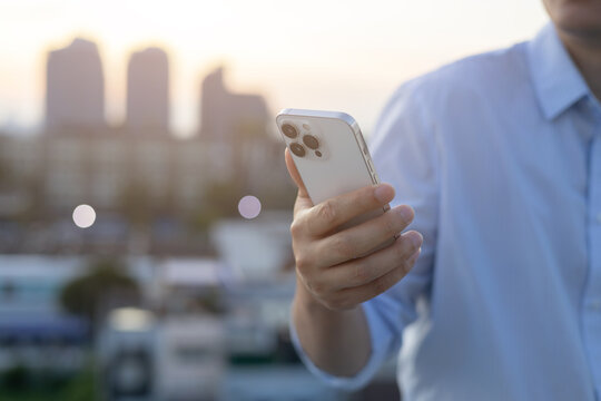 Bangkok,Thailand-  September 29,2024 : man hand hold new Iphone 16 Pro to search information and surf the net on social media application and web at outside office for technology and lifestyle concept