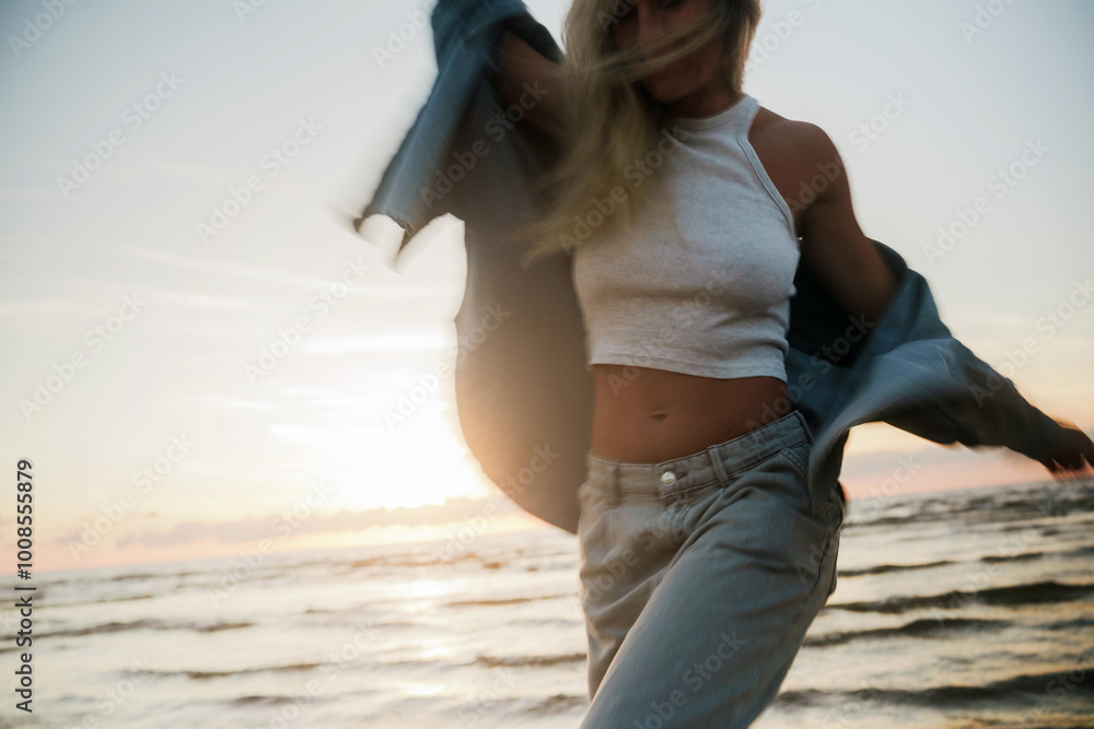 Wall mural creative long exposure shot of woman on beach at sunset