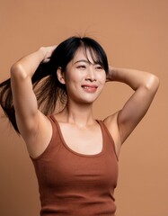 Fototapeta premium portrait of a woman, portrait of asian woman with long black hair, smiling at camera and wearing brown tank top